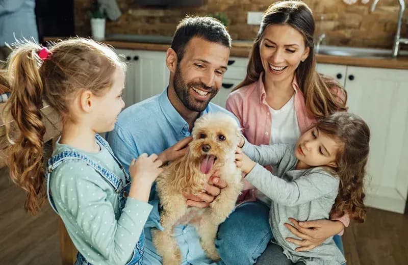 A Portland family and their dog in the kitchen — Wildwoods flea control keeps pets and homes protected.